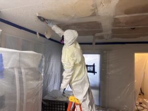 Technician assessing asbestos liability risks 2026 in a Pennsylvania home